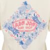 A cream-colored t-shirt featuring a Ron Jon Surf Shop logo surrounded by blue floral and pineapple illustrations with pink accents.