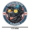 Illustration of a black dog wearing sunglasses and a blue cap with Ron Jon Surf Shop logo, surrounded by text Cocoa Beach Florida 1925. A measurement below reads 1.75 Inches.