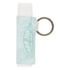 A tube of lip balm with a light green patterned fabric holder and a metal keyring attached.