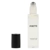 Clear glass bottle labeled Pirette Fragrance Oil with a rollerball applicator and a black cap placed beside it.