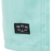 Close-up of a light turquoise fabric with a black patch label that reads Ron Jon Surf Shop featuring a palm tree icon.