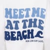 White sweatshirt with blue textured text reading MEET ME AT THE BEACH and RON JON SURF SHOP® on the back.
