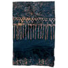 A folded dark blue scarf with abstract tan patterns and fringe on one end. The designs include wavy and geometric motifs.