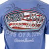 Back of a blue T-shirt with Ron Jon Surf Shop, an American flag design, One of a Kind, and Cocoa Beach printed on it.