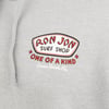 Close-up of a gray garment with a Ron Jon Surf Shop One of a Kind Cocoa Beach, Fla. logo printed in red, black, and white on the chest.