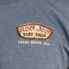 A blue shirt featuring the Ron Jon Surf Shop logo with Cocoa Beach, Fla. text printed beneath the logo.
