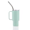 A light green travel mug with a handle, clear lid, and silver metal straw against a white background.