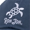 Close-up of a blue cap with a white embroidered turtle and the text Ron Jon.