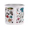 White mug with colorful, cartoon-style summer and beach-themed illustrations, including a sandcastle, surfboard, tiki mask, sunglasses, shirts, and seashells.