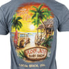 Illustration on a t-shirt showing a beach scene with a surfboard, wooden car, palm trees, a hut, and sunset. Text reads: Ron Jon Surf Shop, Cocoa Beach, Fla., The Good Life.