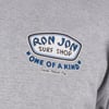 A gray shirt with a Ron Jon Surf Shop One of a Kind Cocoa Beach, Fla. logo printed in blue, black, and white on the chest.