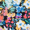 A vibrant floral pattern with various colorful flowers, including blue, yellow, pink, and white blooms, set against a black background.