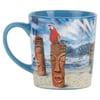 A blue ceramic mug featuring a beach scene with ocean waves, a red parrot on a tiki statue, another tiki statue, and part of a car on the sand.