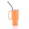 Orange insulated cup with handle, clear lid, and silver metal straw against a white background.