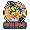 A colorful sign featuring palm trees, a sunset, and Ron Jon Surf Shop above the text Cocoa Beach Florida.
