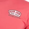 Close-up of a watermelon colored shirt featuring a Ron Jon Surf Shop Ocean City, MD logo on the upper left chest.