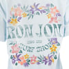 Light blue t-shirt featuring Ron Jon Surf Shop Since 1959 text surrounded by colorful floral designs in yellow, pink, orange, and purple.