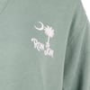 Close-up of a green fabric with a white graphic featuring a crescent moon, a palm tree, and the text RON JON.