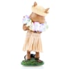 A figurine of a pig wearing a straw hat, a flower lei, and a grass skirt, standing on a decorated green base, viewed from behind.