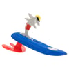 A toy shark wearing sunglasses and a red swimsuit is attached to a blue and red surfboard.