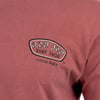 Close-up of a red shirt with a Ron Jon Surf Shop Cocoa Beach logo printed on the chest.