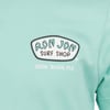 Close-up of a mint green shirt featuring the Ron Jon Surf Shop logo and Cocoa Beach, Fla text on the chest.