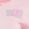 Close-up of a pink-colored shirt featuring the Ron Jon Surf Shop logo in pink letters with a green checkered border on the chest area.