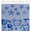 A blue towel with white fringe features dark blue illustrations of starfish, a crab, seashells, and an anchor on a light blue background.