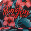 Close-up of a hat featuring a tropical floral pattern with hibiscus flowers and leaves. The text Ron Jon Surf Shop is embroidered in red on the front.