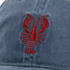 Close-up of a blue cap featuring a red embroidered lobster design on the front.
