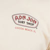 Close-up of a Ron Jon Surf Shop logo with Cocoa Beach, FL printed below on a white shirt.