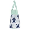 Side view of a mint green tote bag with navy blue turtle designs and two matching handles.