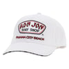 White baseball cap with Ron Jon Surf Shop and Panama City Beach embroidered on the front; black text on the brim edge.
