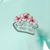 A mint shirt features a Ron Jon Surf Shop logo with pink hibiscus flowers.