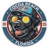 Circular logo featuring a black dog wearing sunglasses and a blue cap labeled Ron Jon Surf Shop, with text reading Cocoa Beach Florida 1925.