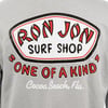 Gray shirt featuring a large Ron Jon Surf Shop, One of a Kind, Cocoa Beach, Fla. logo in red, white, and black text on the back.