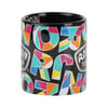 Black ceramic mug with multicolored, geometric letters and shapes, and a white RON SHOP logo on the side.