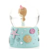 Snow globe with a figurine of a girl inside, featuring a blue base adorned with starfish and seashell motifs.
