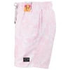 Pink board shorts with a white tropical pattern, featuring two labels: one small and black near the hem, and a larger colorful one near the waistband.