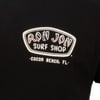 Close-up of a black T-shirt featuring the Ron Jon Surf Shop logo and the text Cocoa Beach, FL printed on the front.