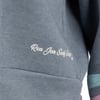 Close-up of a gray sweatshirt showing the Ron Jon Surf Shop logo in white on the fabric.