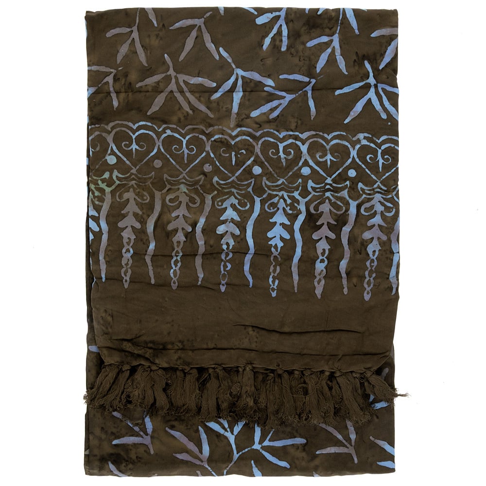 A folded dark brown fabric with blue batik-style leaf and heart patterns, featuring a fringe at one end.