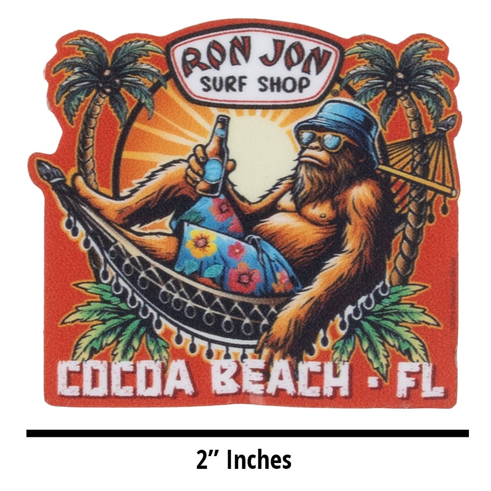Illustration of a relaxed orangutan in a hammock with a drink, wearing sunglasses and a bucket hat, under palm trees. Text: Ron Jon Surf Shop, Cocoa Beach, FL. Measures 2 inches.