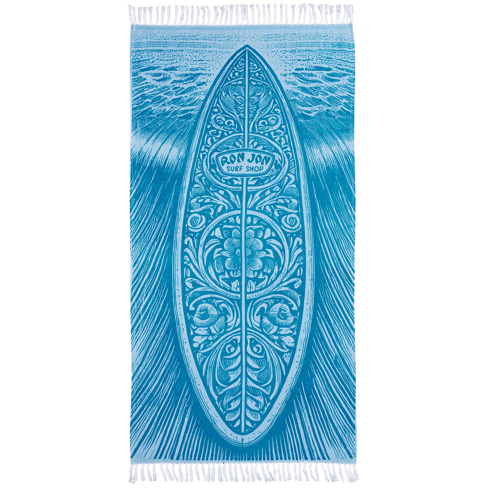 A blue beach towel featuring an illustrated surfboard with floral patterns and the text RON JON SURF SHOP in the center, with fringed edges on both ends.