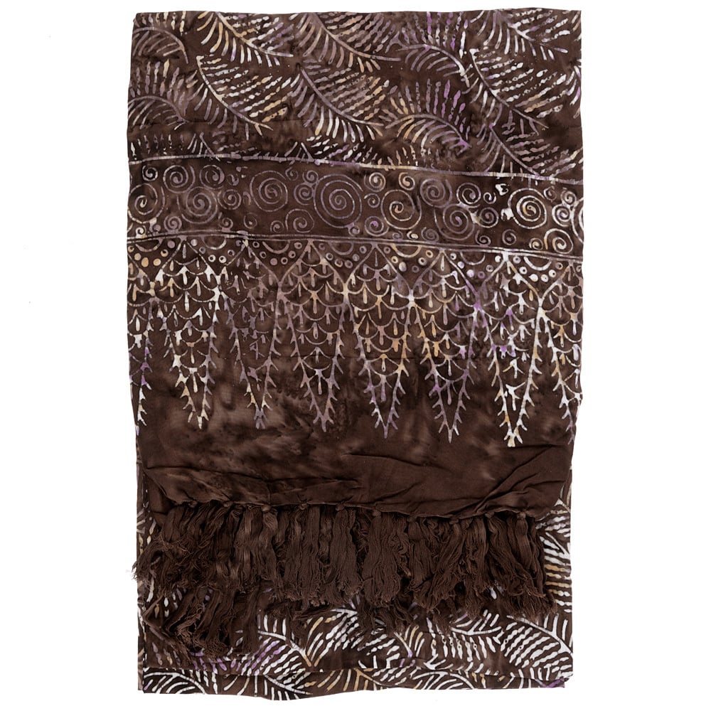 A brown fabric with light-colored, leaf-like patterns, swirling designs, and fringe on one end is neatly folded.