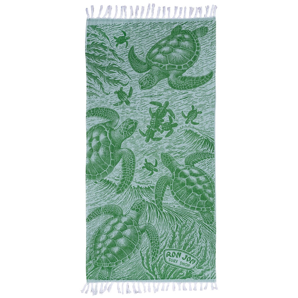 A green beach towel featuring illustrations of sea turtles swimming underwater, with Ron Jon Surf Shop printed in one corner and fringes on both ends.
