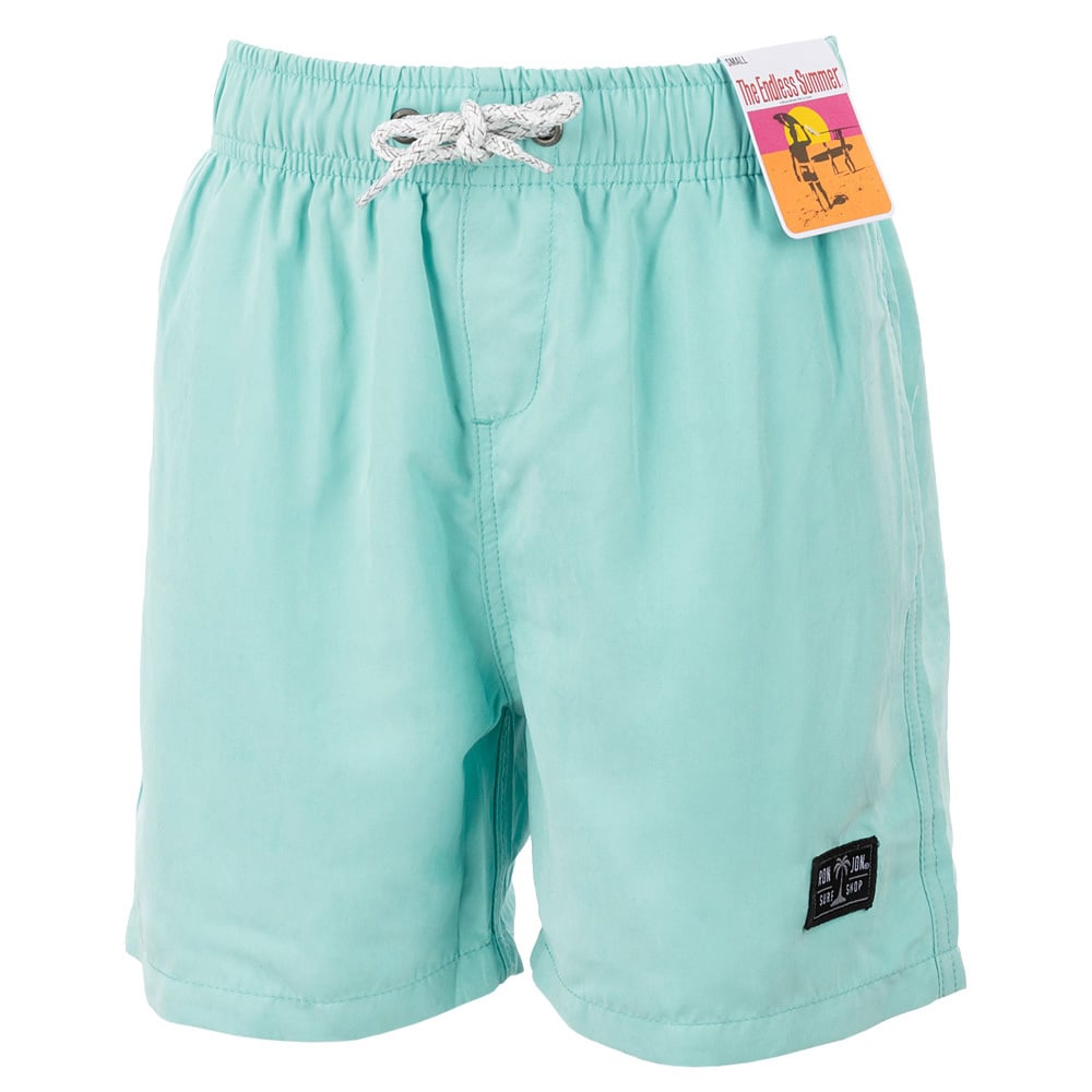 Light blue swim shorts with white drawstrings and a small black logo patch on the leg. A tag is attached near the waistband.