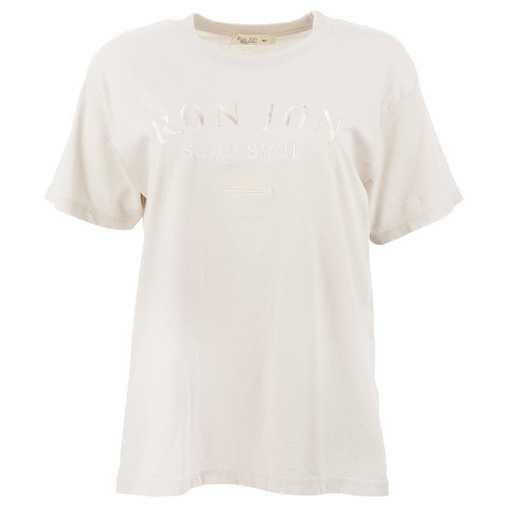 A plain beige short-sleeve T-shirt with RON JON SURF SHOP and a small sun design embroidered in white on the front.