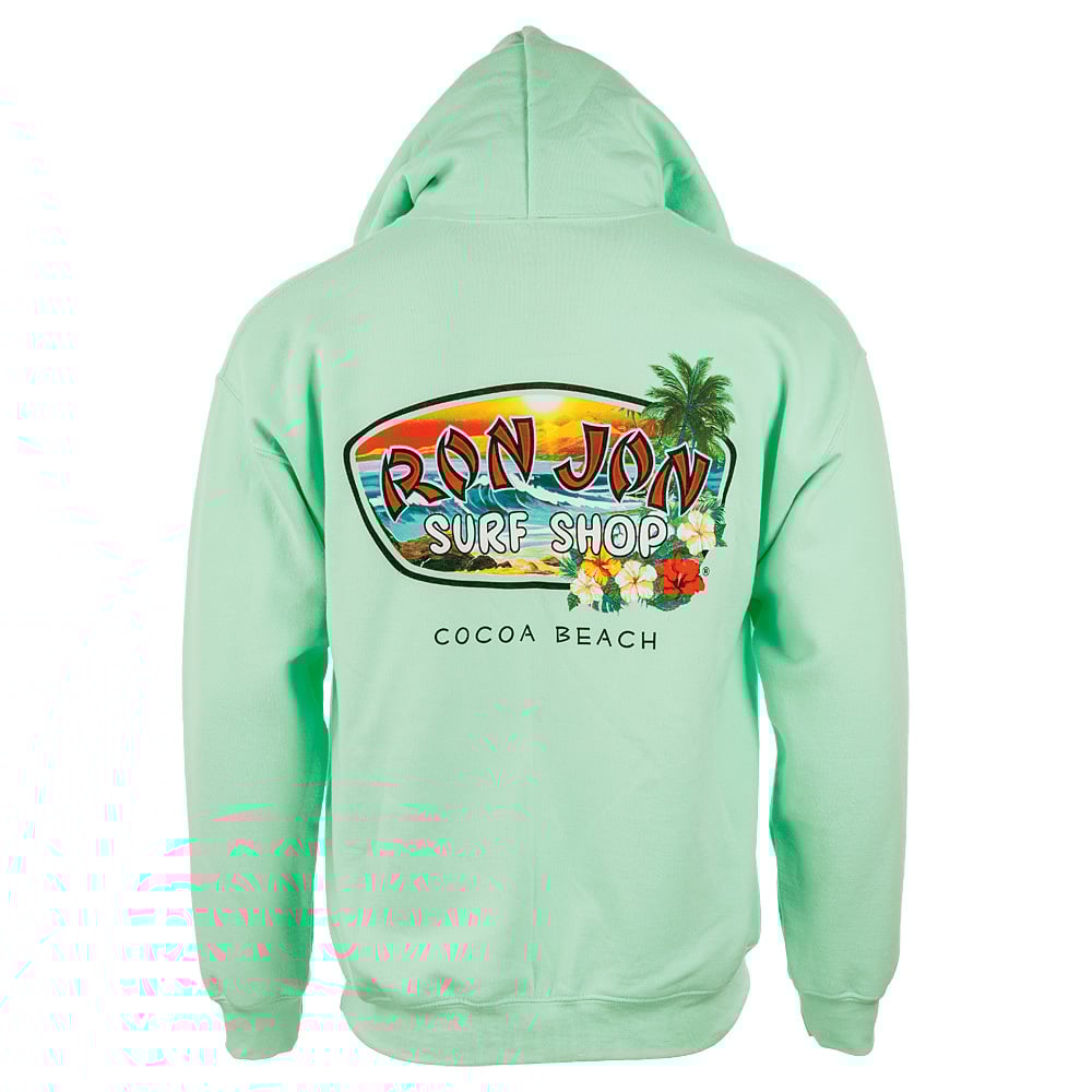 The image shows the back of a light green hoodie featuring Ron Jon Surf Shop and Cocoa Beach with a colorful surfboard and tropical motif.