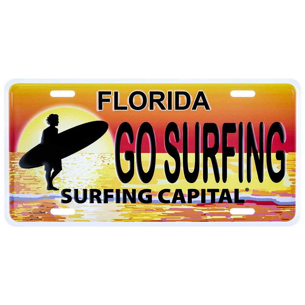 A decorative license plate with a sunset, a surfer carrying a surfboard, and the text Florida Go Surfing Surfing Capital.